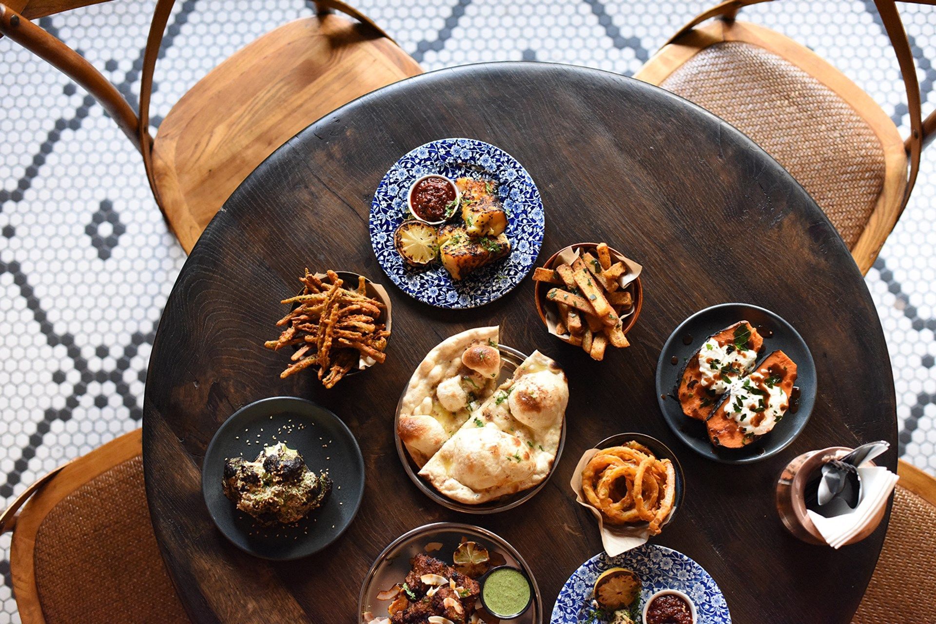Sharing plates on a wooden table at Tandoor Chop House, Charing Cross
