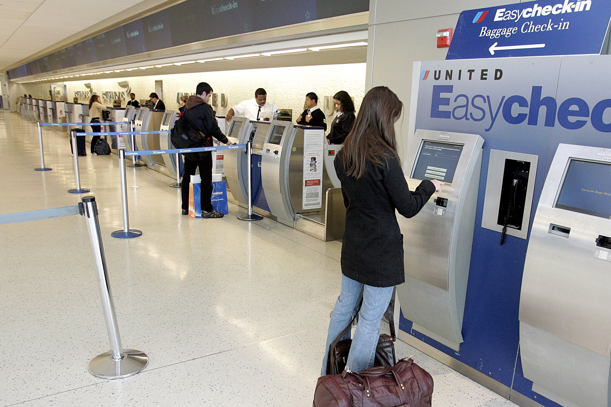 Traveler using a self-service check-in kiosk at JFK Airport